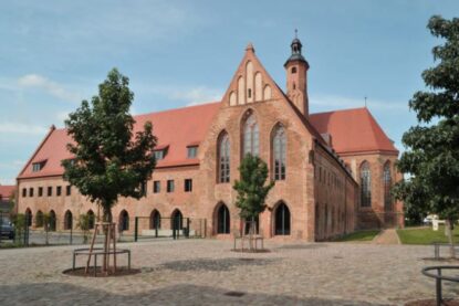 Man sieht das Archäologische Landesmuseum in Brandenburg. Dort sehen sich Menschen Funde an.